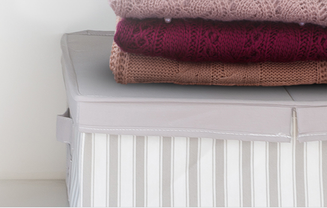 부직포 수납함 위에 3개의 니트가 쌓여있는 이미지      